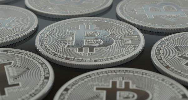Close-up of several silver cryptocurrency coins with a bitcoin logo
