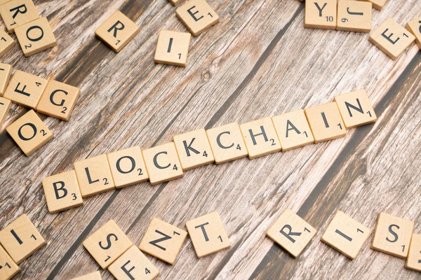 Wooden scrabble tiles spelling the word blockchain on a table